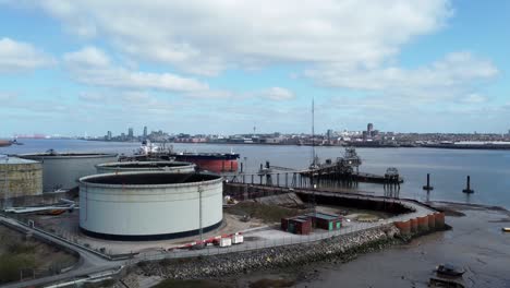 british industrial crude oil distribution pipeline terminal aerial rising view across shipping refinery