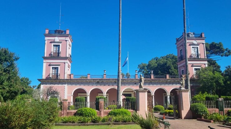 Vista dello storico Palacio San José a Entre Ríos, in Argentina, in una luminosa giornata di sole, che mette in mostra l'elegante architettura coloniale circondata da una vegetazione rigogliosa e giardini curati