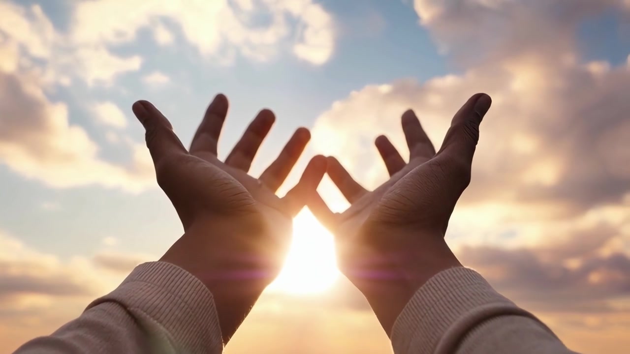 Persona che allunga le mani verso il sole al tramonto
