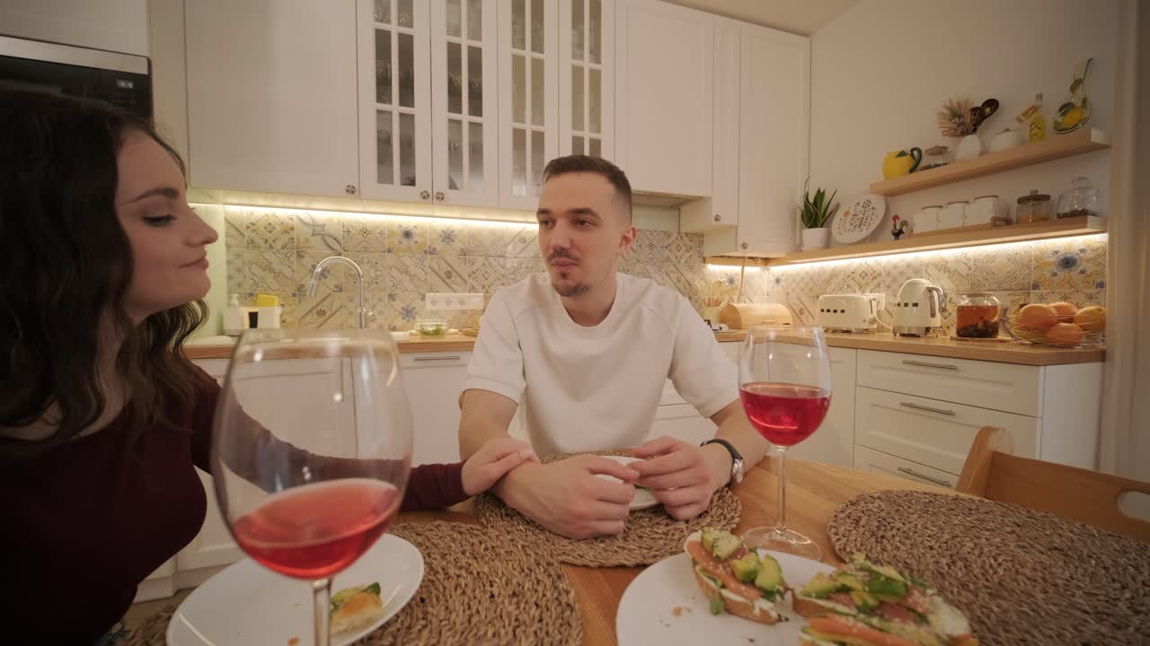 una pareja enamorada haciendo un sándwich en la cocina de la sala de estar