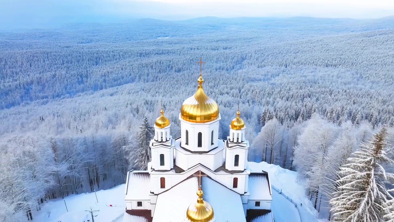 Perspective aérienne élevée montrant une petite église orthodoxe blanche surmontée de dômes et de croix dorés étincelants, située au centre inférieur du premier plan au milieu d'un vaste