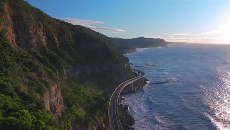 sunrise sea cliff bridge aerial drone view iconic famous stanwell park cars driving waves south coast nsw australia landscape royal national park wollongong coalcliff iiawarra sydney circle right