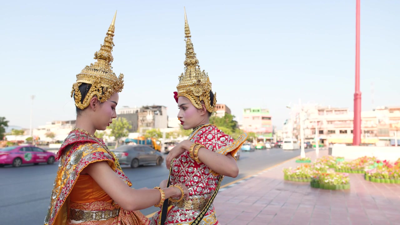 Due ballerine thailandesi in costumi tradizionali che si preparano per uno spettacolo.