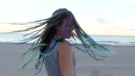 woman with braids dancing on the beach