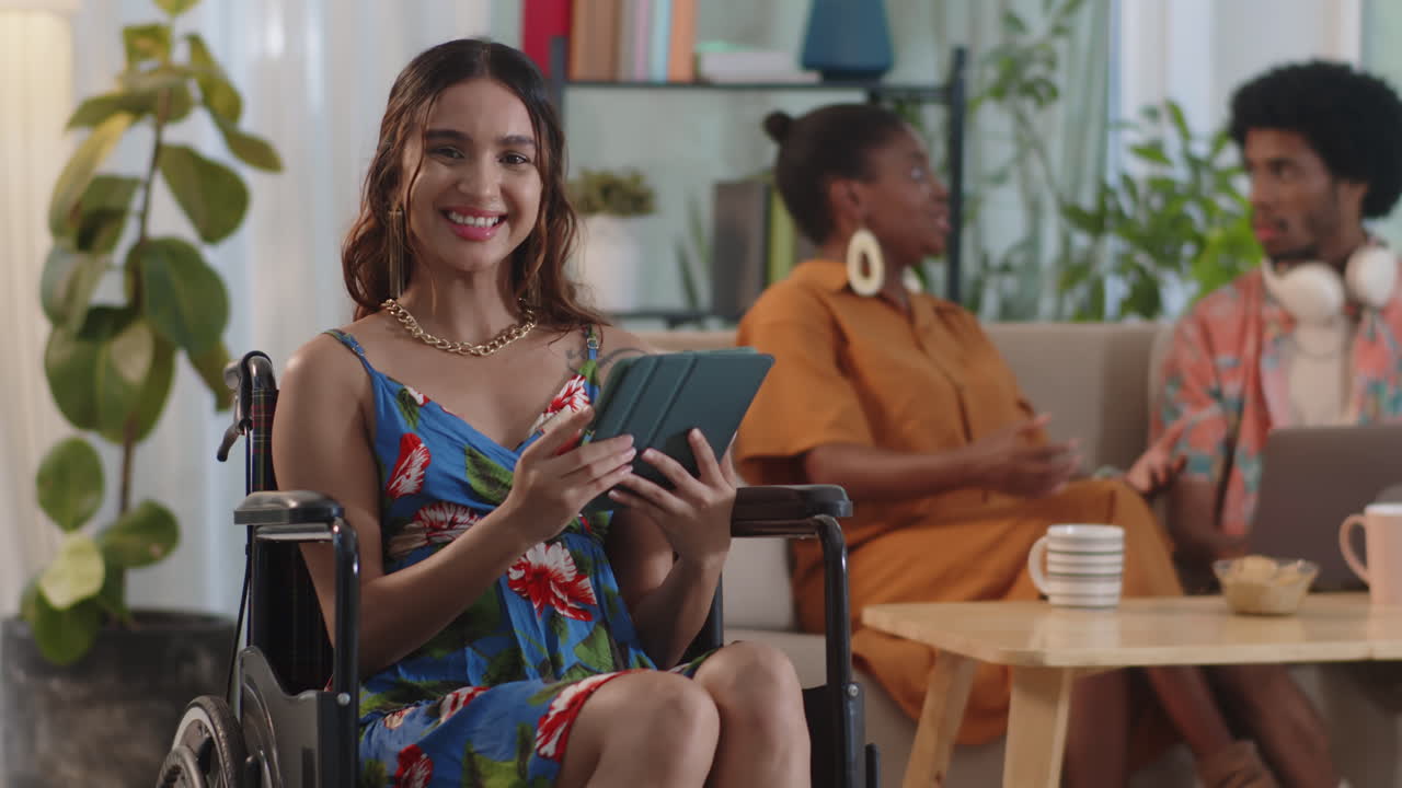 Woman in Wheelchair Holding Digital Tablet and Smiling at Camera