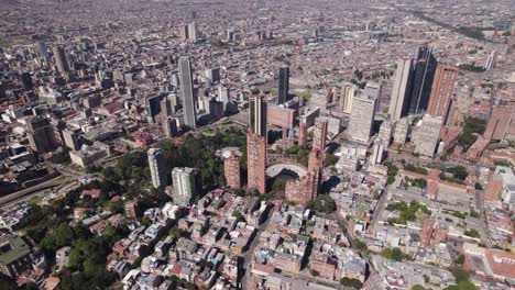 fotografía de alto ángulo de un avión no tripulado rodeando el horizonte de la ciudad de bogotá, un día soleado en colombia