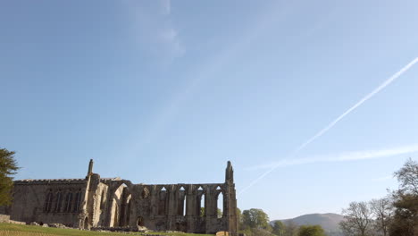 tilt reveal of bolton abbey ruins on a beautiful sunny summer’s morning in yorkshire, england