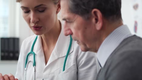 handheld view of doctor and patient analyzing the medical results in doctor office