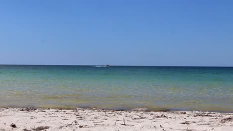 small boat in the distance and clear blue waters busselton, australia