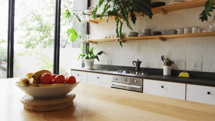 Viene mostrato un interno di cucina moderno, con luce naturale che filtra