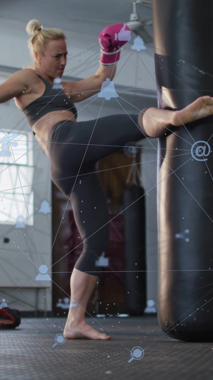 Vertical video: Boxer stepping, striking bag, training, pink gloves, blue network overlay scrolling