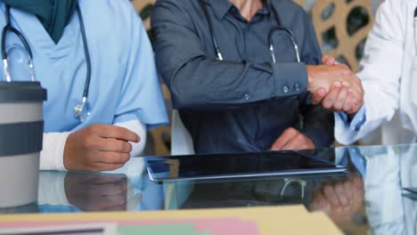 médicos sentados estrechando la mano 4k