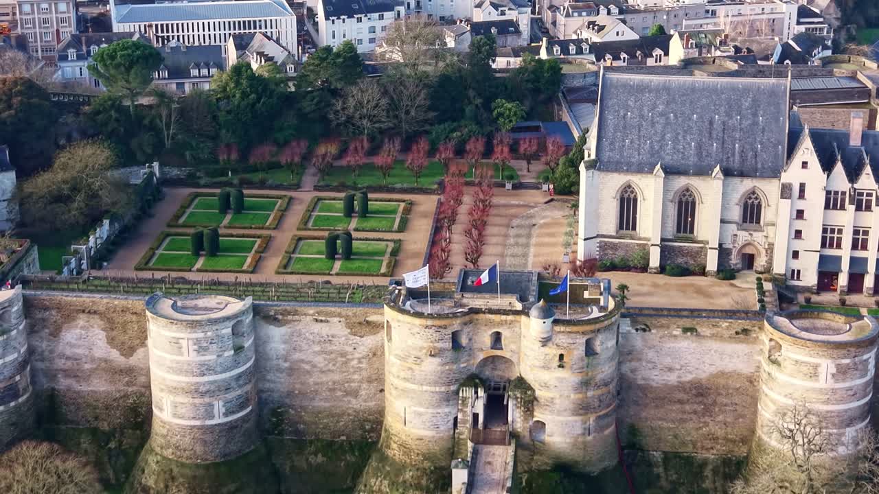 Drone vliegt richting de poort van Château d’Angers over de historische gracht. Frankrijk. Neerwaartse kantelende luchtopname