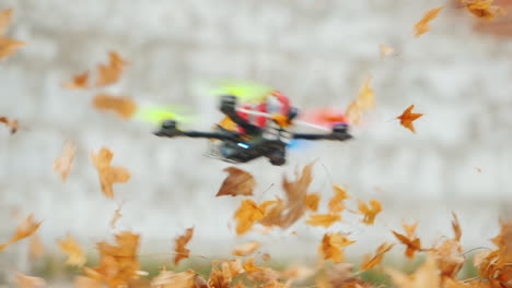 the quadcopter flies low above the ground effectively lifting the fallen leaves into the air