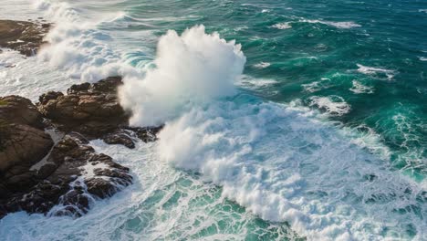 a stunning view of ocean waves crashing against rugged rocks, capturing the dynamic movement and vibrant colors of coastal nature in a timeless scene