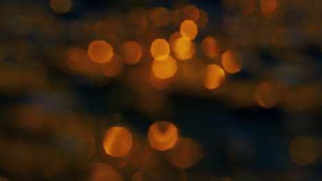 bokeh lights shining on sea water surface at golden sunset. sunlight reflection