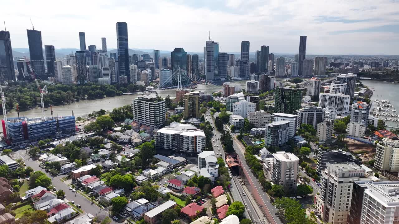Highway to Brisbane city and downtown with skyscrapers on riverside. Australian big city. Aerial birds eye