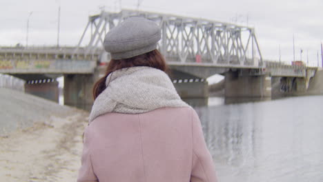 mujer caminando por un puente en un día nublado