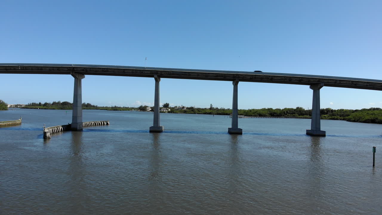 A panning aerial shot of one of the many causeways spanning the Indian River Lagoon