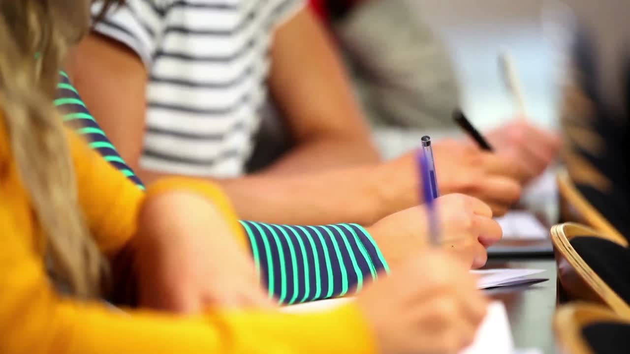 Row of students taking notes in class