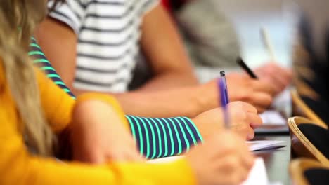 fila de estudiantes tomando notas en la clase
