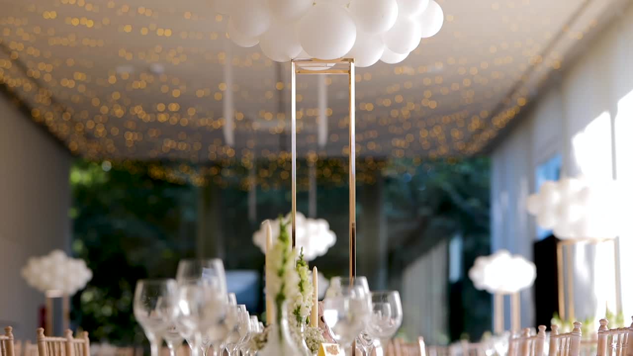"Wedding or Christening Event Table Decoration with White Colors, Balloons, Plates, and Cutlery Tableware in Slow Motion