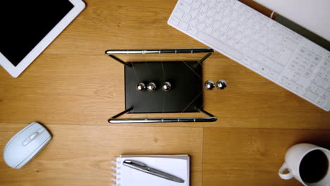 overhead of newtons cradle toy on office desk