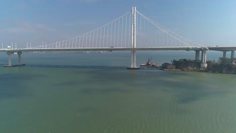 aerial shot of vehicles moving on san francisco–oakland bay bridge with city in background