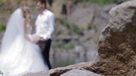 Bride And Groom Near The Large Stones. Bride and groom standing near the large stones. Happy couple