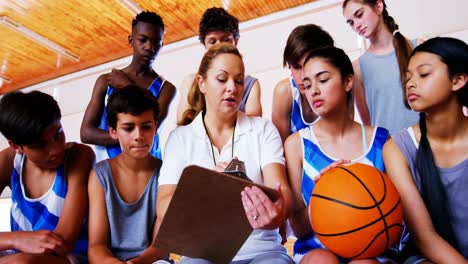 Coach-instructing-a-students-in-basketball-court