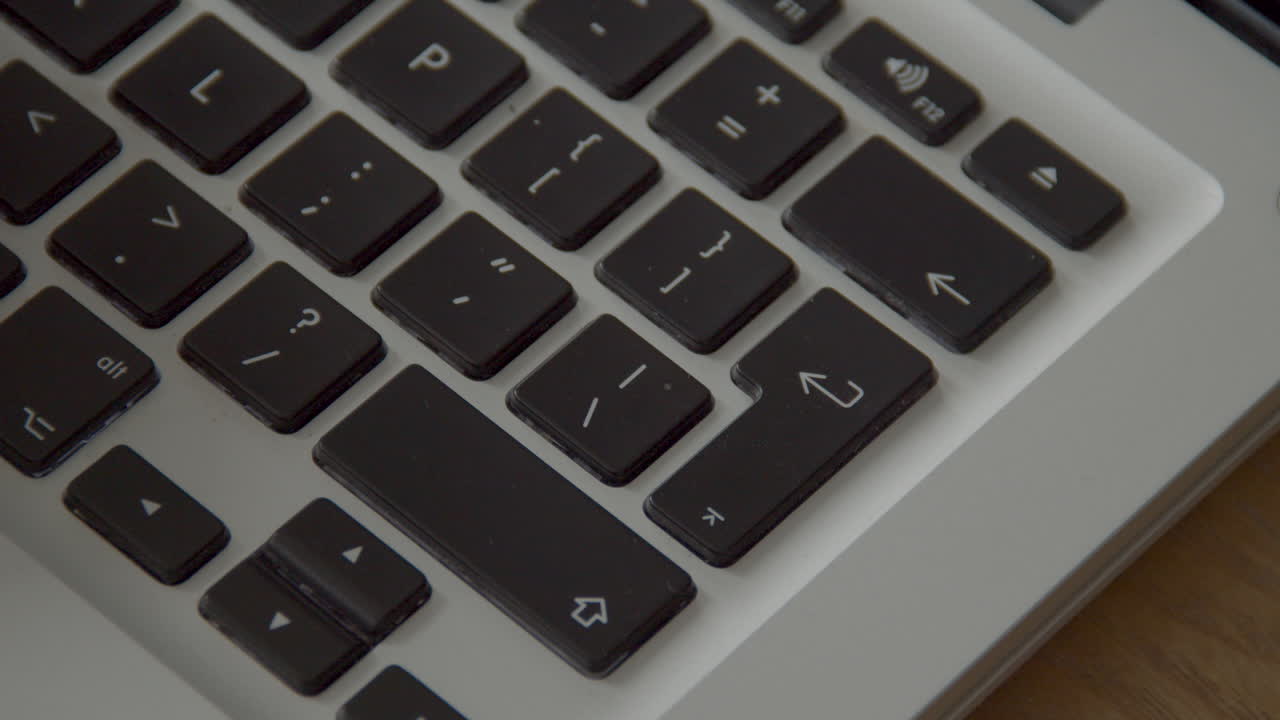 палец несколько раз нажимает на кнопку ввода на клавиатуре ноутбука во время набора текста