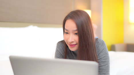 Close-up-of-a-pretty-young-woman-working-on-her-laptop-then-reacting-with-joy-at-her-success