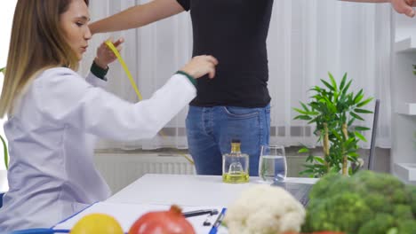 doctor measuring men waist body fat. obesity and weight loss.