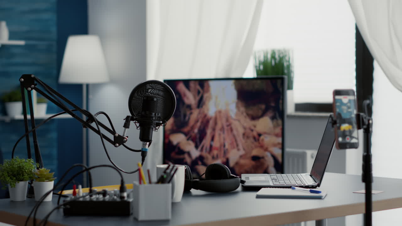 Happy creator sitting at podcast desk with studio microphone and computer