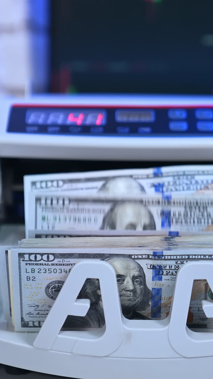 Finance business money counting. Cropped view of the person putting money at the bank cash counter machine. Money concept. Vertical video