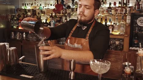 un camarero preparando un cóctel en un bar