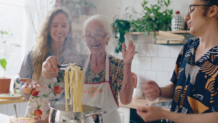 Happy Elderly Woman and Grandchildren Cooking Homemade Pasta Together