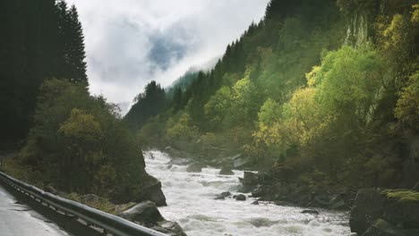 a wild mountain river rushes along the narrow road