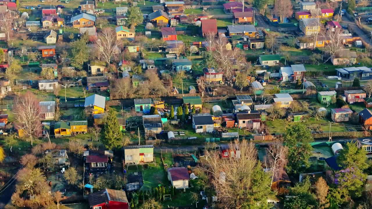 Cinematic aerial shot show colorful garden plots, cabins, Riga Kurzeme district
