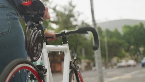 sezione media di una donna biraciale in città, che cammina in bicicletta