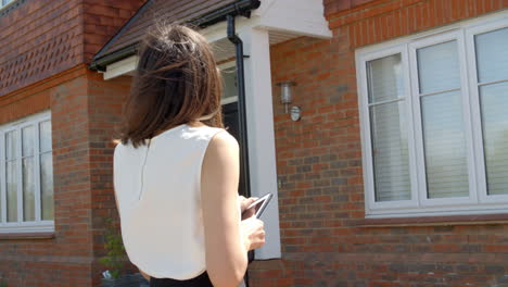 female realtor valuing property using digital tablet