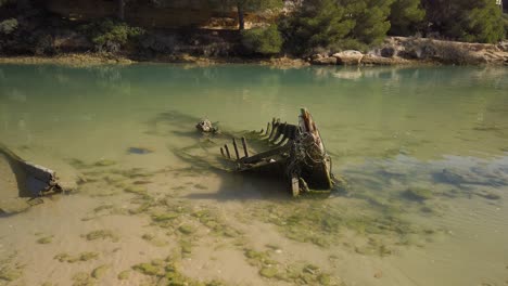 tilt down reveal of sunken skeleton boat in calm waters