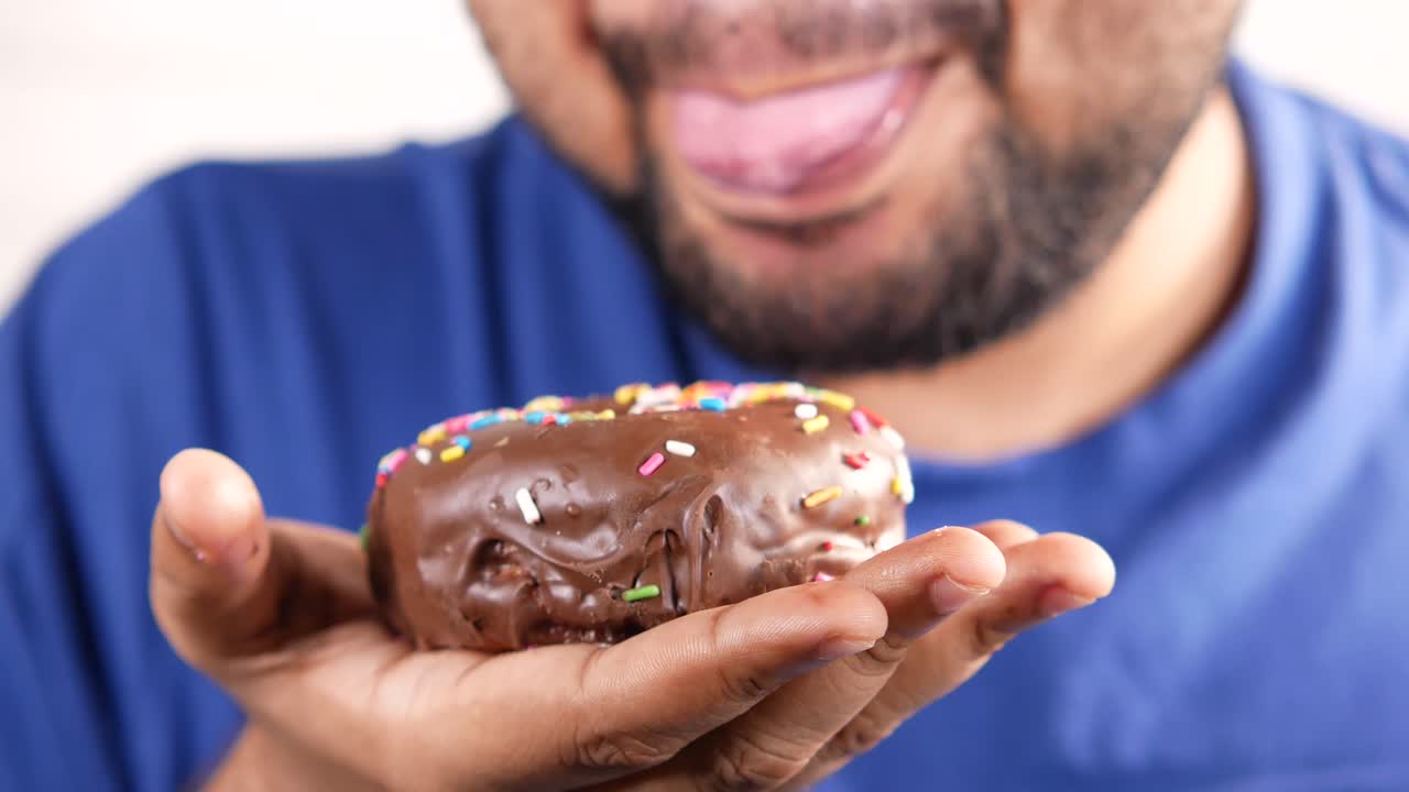 persona comiendo una rosquilla de chocolate