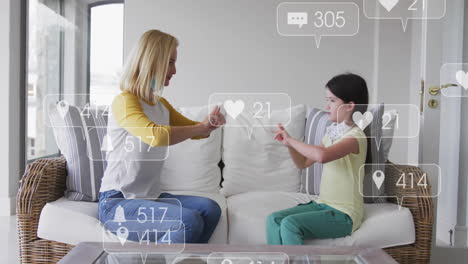 social media interaction icons animation over woman and child playing hand game