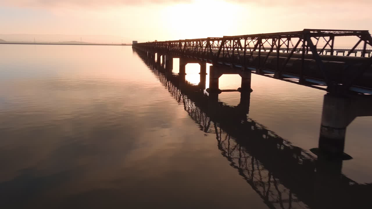 Dumbarton Rail Bridge, South Of The Dumbarton Road Bridge In The San Francisco Bay Area At Sunrise - Drone Shot