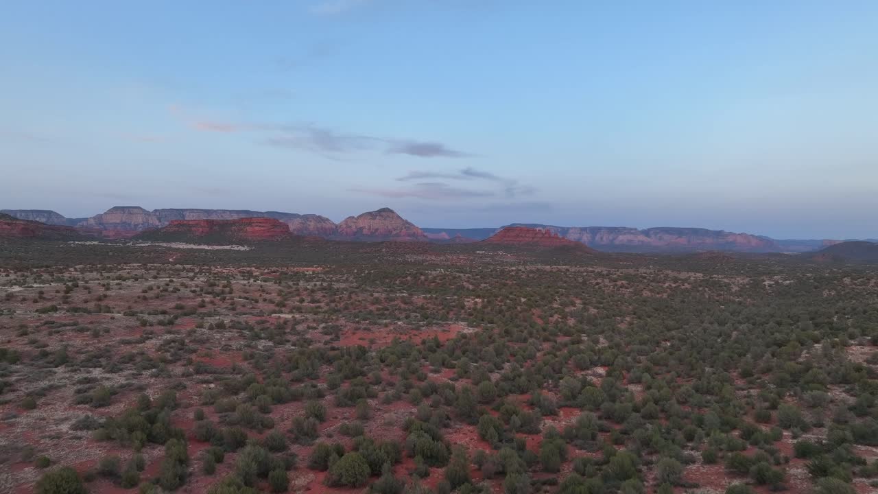 llanuras con arbustos en crecimiento cerca de las montañas de roca roja en sedona, arizona