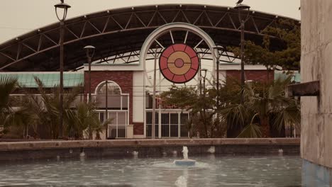 shot of building with circular entrance and water fountain in rainy day