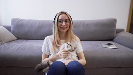 webcam view woman in headphones hugs cat shoots video for blog with pet