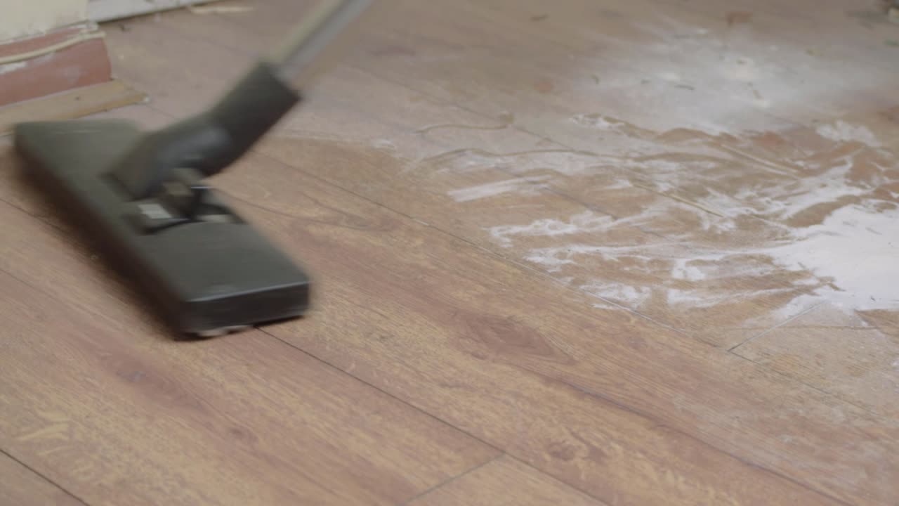 전기 진공 청소기로 더러운 먼지가 많은 바닥을 청소합니다.