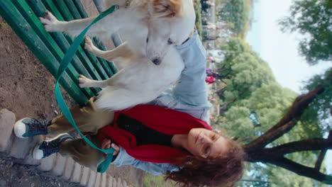 woman petting cute dog on park bench